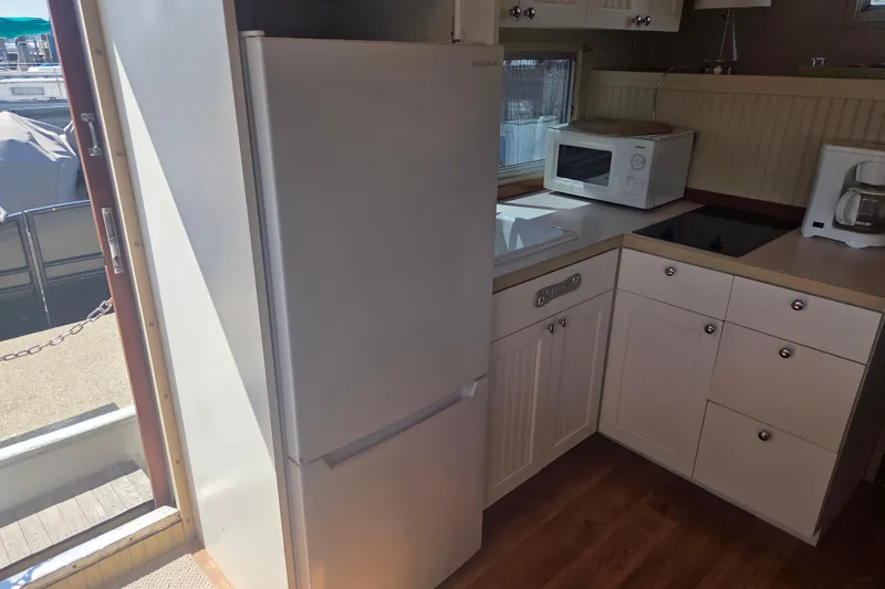 Slide: The Image of Compact kitchen in a 1973 River Queen Star Stream boat with fridge, microwave, and stove. - 13