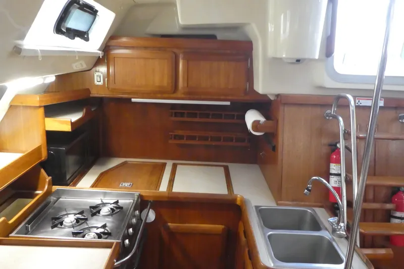 Slide: The Image of 1992 Hunter Passage 42 yacht kitchen with stove, sink, and wooden cabinetry. - 17