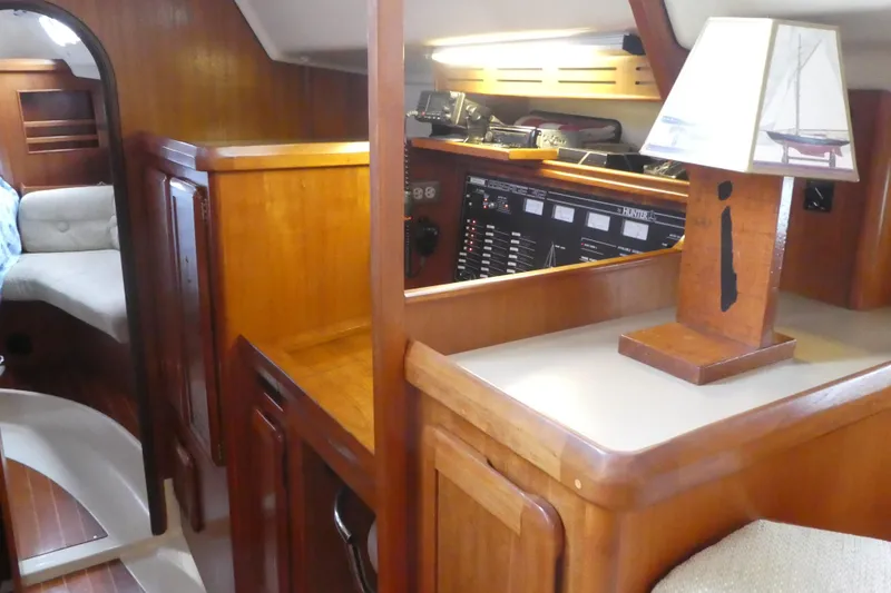 Slide: The Image of Interior of 1992 Hunter Passage 42 sailboat with wooden cabinetry and nautical-themed lamp. - 19