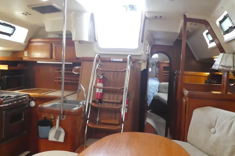 Slide: The Image of Interior of a 1992 Hunter Passage 42 sailboat with wood finishes and cozy seating. - 15