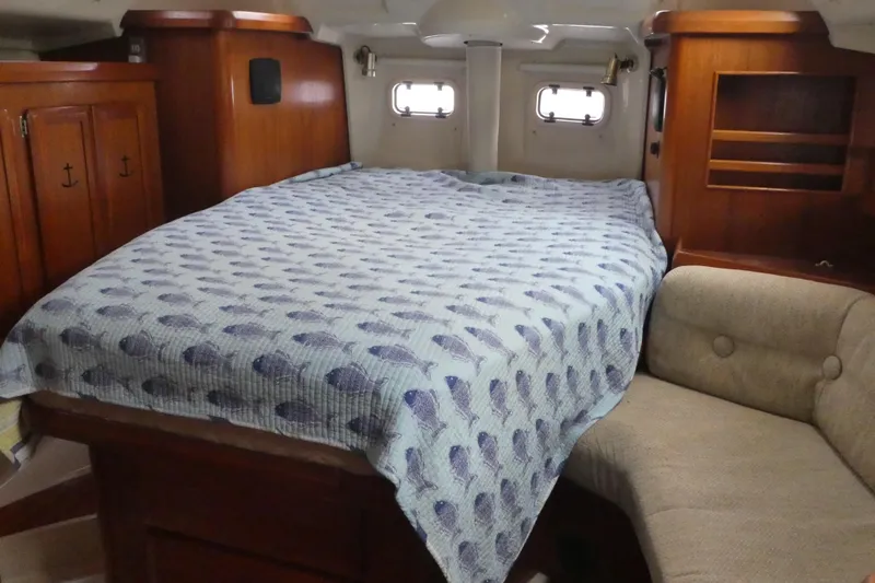 Slide: The Image of Cozy cabin interior of 1992 Hunter Passage 42 sailboat with bed and wooden furnishings. - 22