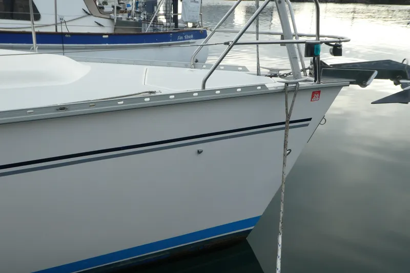 Slide: The Image of 1992 Hunter Passage 42 sailboat docked, featuring sleek white hull and blue stripe. - 4