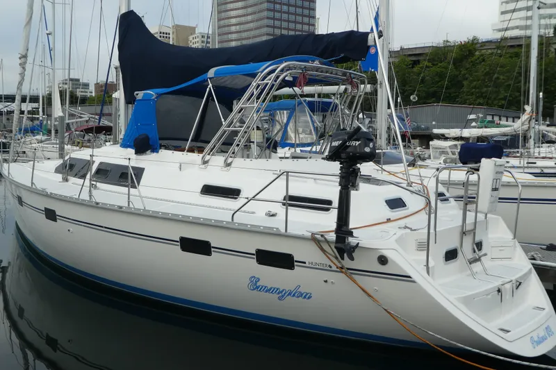 The Image of 1992 Hunter Passage 42 sailboat docked in marina, featuring sleek design and Mercury outboard motor. - 1