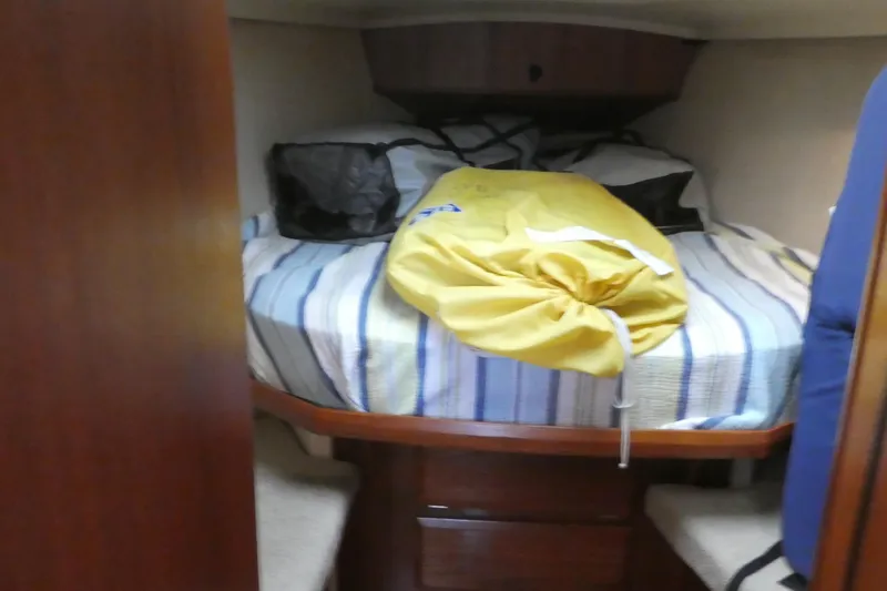 Slide: The Image of Cozy cabin interior of 1992 Hunter Passage 42 sailboat with striped bedding. - 31