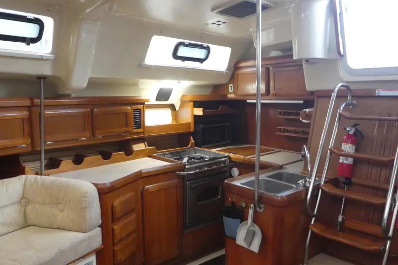 Slide: The Image of Interior of 1992 Hunter Passage 42 yacht with wooden cabinetry and kitchen amenities. - 16