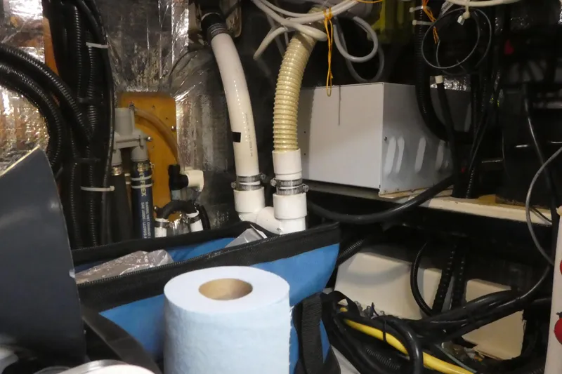 Slide: The Image of Engine room of a 1992 Hunter Passage 42 sailboat with hoses and equipment. - 35