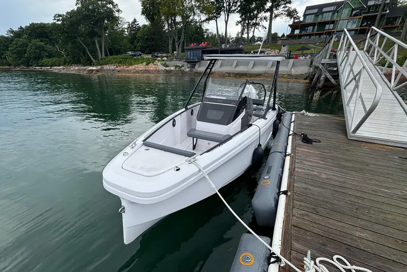 Slide: The Image of 2022 Axopar 22 T-Top boat docked by a scenic lakeside pier. - 4