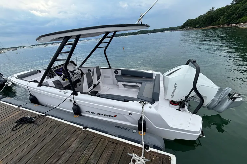 Slide: The Image of 2022 Axopar 22 T-Top boat docked, featuring sleek design and Mercury outboard engine. - 5