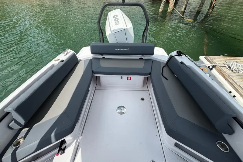 Slide: The Image of 2022 Axopar 22 T-Top boat interior with seating, docked by the water. - 11