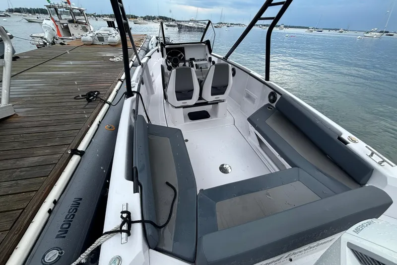 Slide: The Image of 2022 Axopar 22 T-Top boat docked, featuring sleek seating and modern design. - 12
