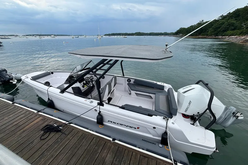 Slide: The Image of 2022 Axopar 22 T-Top boat docked by a serene waterfront. - 7