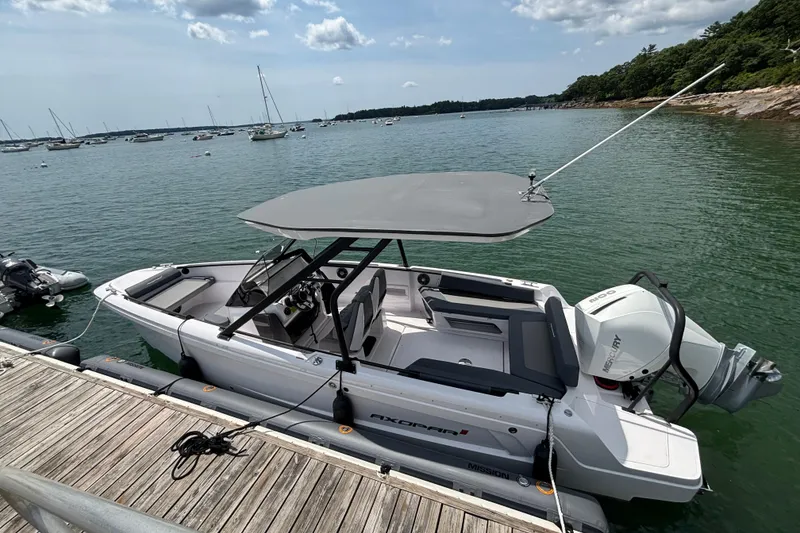 Slide: The Image of 2022 Axopar 22 T-Top boat docked by the water, featuring a sleek design and Mercury engine. - 3