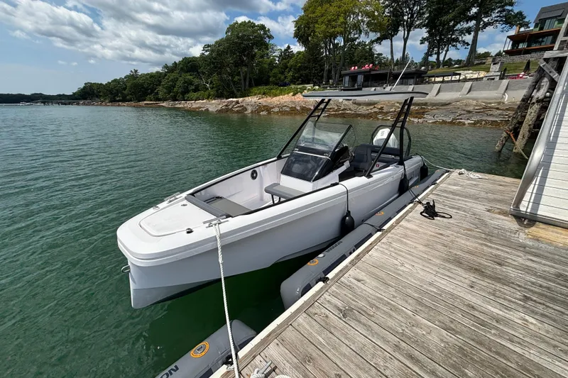 Slide: The Image of 2022 Axopar 22 T-Top boat docked by a scenic shoreline with trees. - 6
