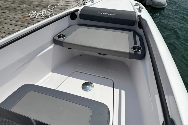 Slide: The Image of 2022 Axopar 22 T-Top boat interior with cushioned seating and cup holders. - 13