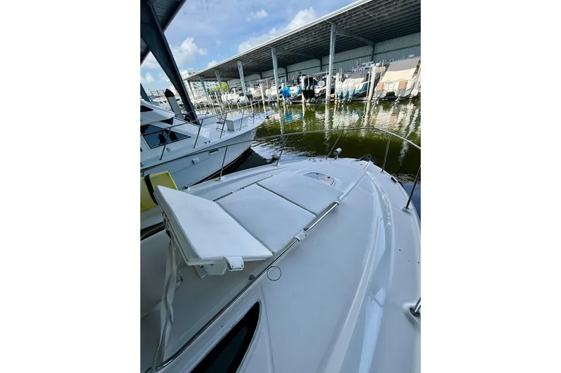 Slide: The Image of 2008 Sea Ray Sundancer 330 docked in a marina under a covered area. - 12