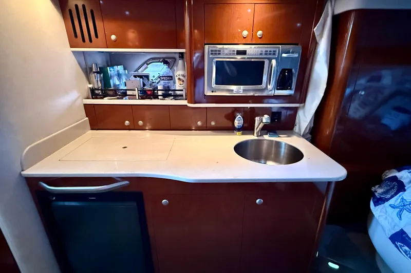 Slide: The Image of 2008 Sea Ray Sundancer 330 galley with sink, microwave, and storage cabinets. - 15