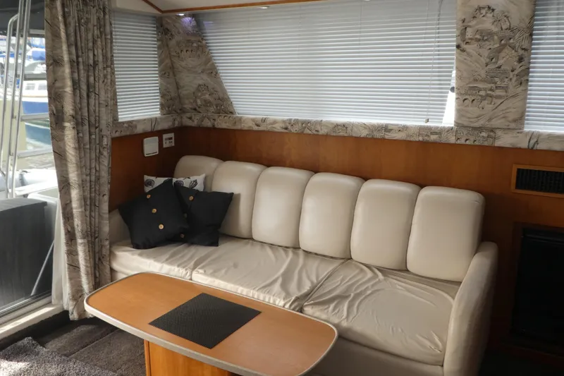 Slide: The Image of Interior of 1997 Silverton 41 Convertible yacht with beige sofa and wooden table. - 4