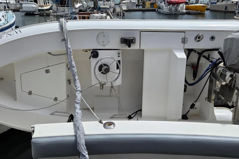 Slide: The Image of 1997 Silverton 41 Convertible boat interior with steering wheel and docked boats in background. - 43