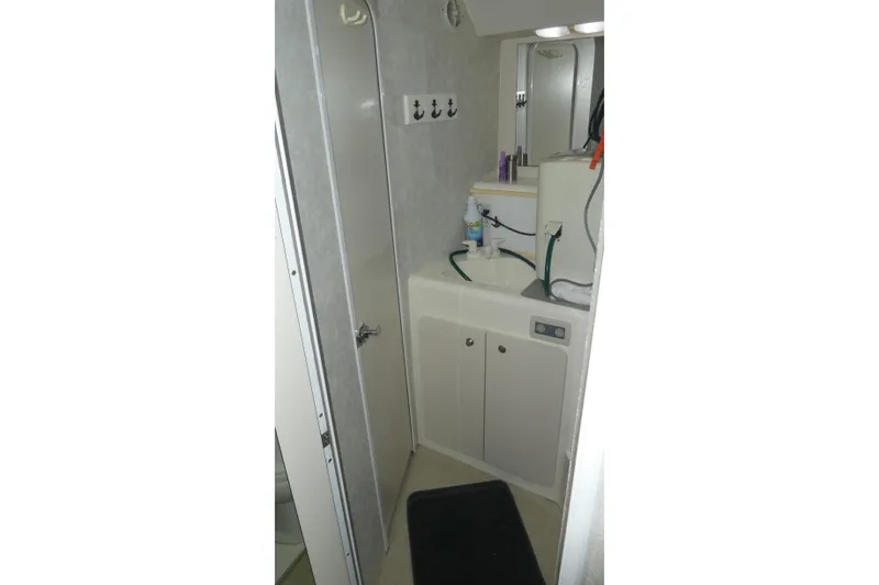 Slide: The Image of 1997 Silverton 41 Convertible yacht bathroom with sink, mirror, and storage cabinets. - 14