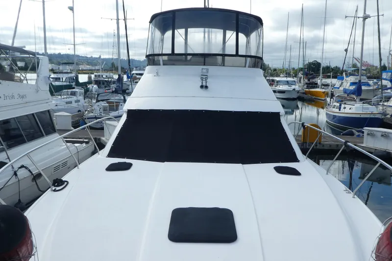 Slide: The Image of 1997 Silverton 41 Convertible yacht docked at a marina, surrounded by other boats. - 34