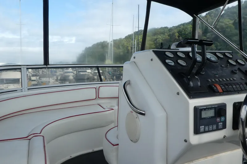 Slide: The Image of 1997 Silverton 41 Convertible yacht helm with white seating and control panel. - 39