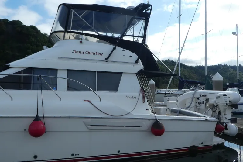 The Image of 1997 Silverton 41 Convertible yacht docked at marina with scenic background. - 1