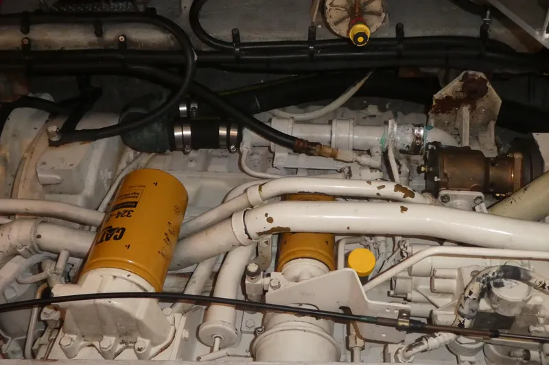 Slide: The Image of Engine compartment of a 1997 Silverton 41 Convertible boat, featuring CAT filters and piping. - 28