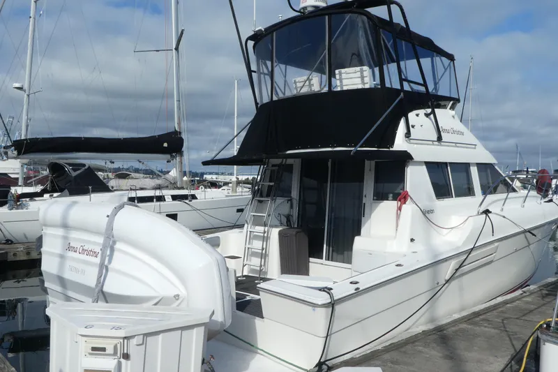 Slide: The Image of 1997 Silverton 41 Convertible yacht docked at marina under cloudy sky. - 0