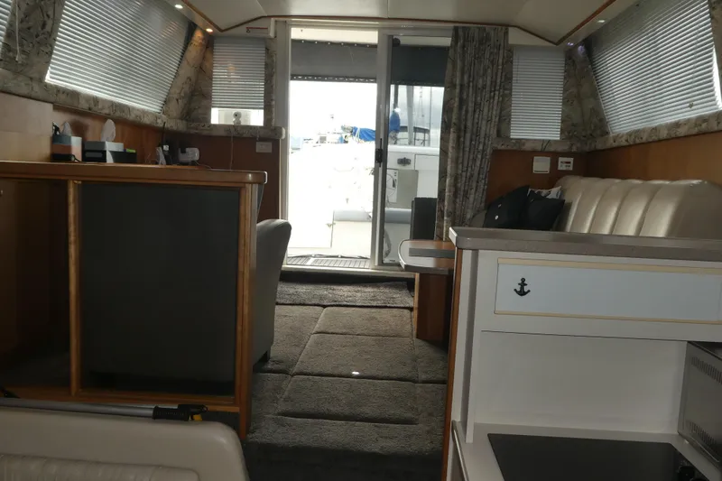 Slide: The Image of Interior of a 1997 Silverton 41 Convertible yacht, featuring a cozy seating area and modern decor. - 13