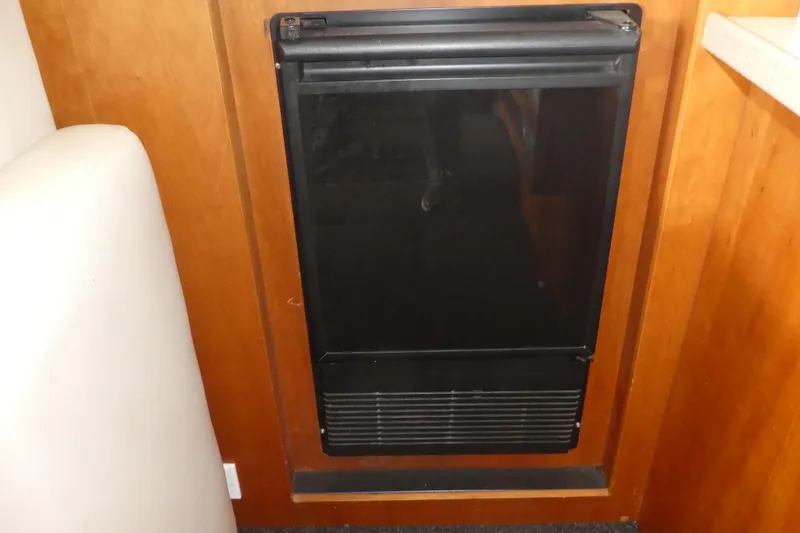 Slide: The Image of Black refrigerator in 1997 Silverton 41 Convertible boat interior, surrounded by wooden cabinetry. - 20