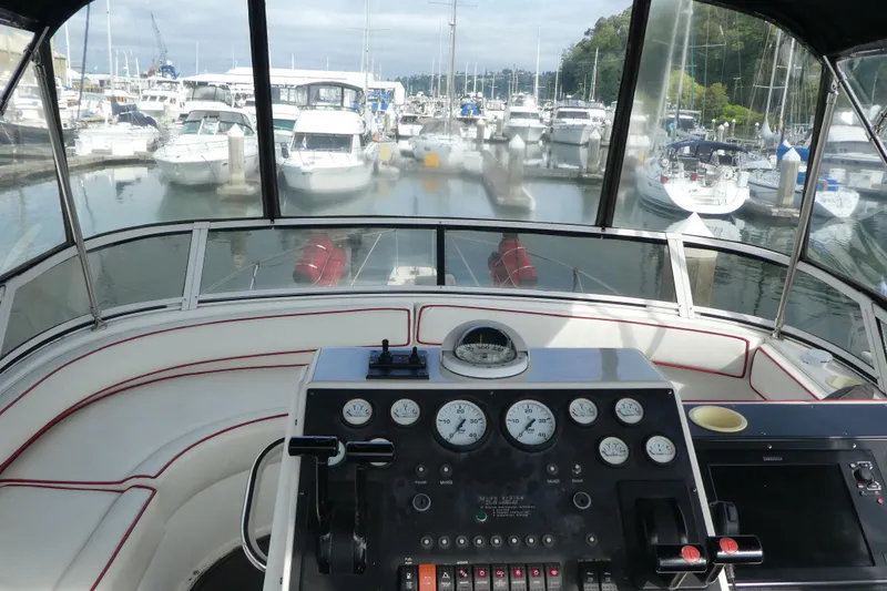 Slide: The Image of Helm of 1997 Silverton 41 Convertible yacht in marina, showcasing control panel and gauges. - 35