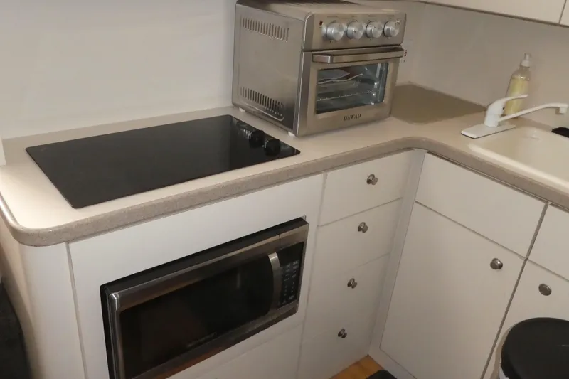 Slide: The Image of Compact kitchen area in a 1997 Silverton 41 Convertible boat with modern appliances. - 6