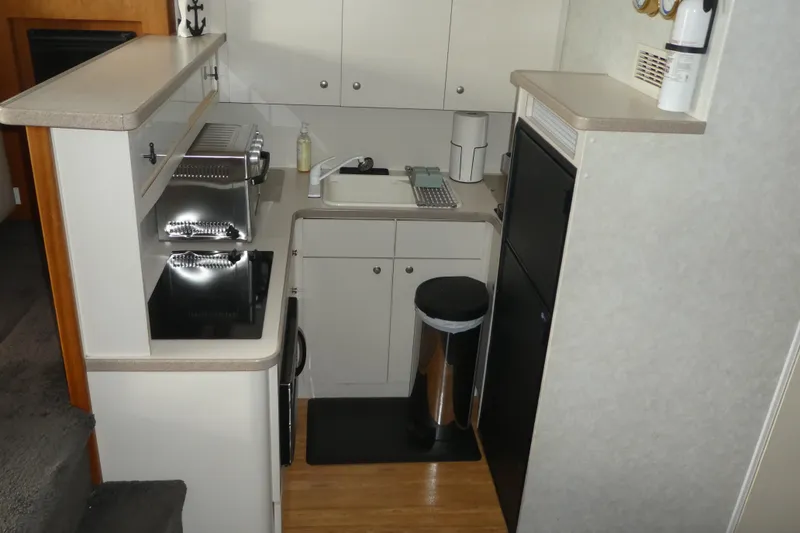 Slide: The Image of Compact kitchen area in a 1997 Silverton 41 Convertible boat, featuring modern appliances. - 5