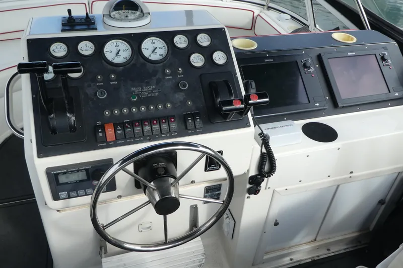 Slide: The Image of 1997 Silverton 41 Convertible helm with gauges, steering wheel, and navigation screens. - 40