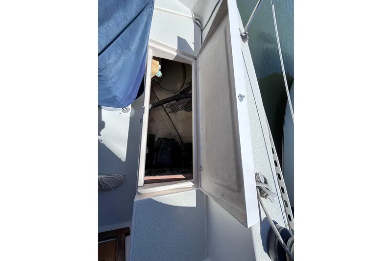 Slide: The Image of Open hatch on 1984 Islander 28 sailboat deck, revealing storage area. - 31