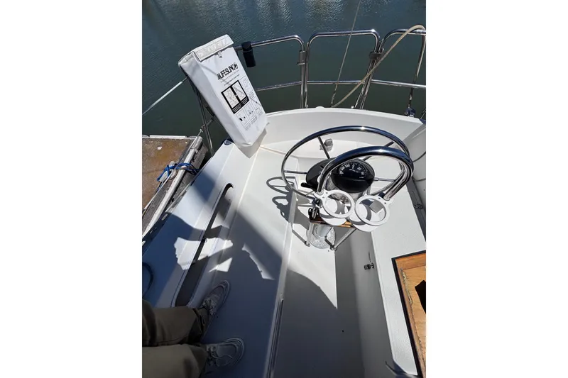 Slide: The Image of Cockpit of 1984 Islander 28 sailboat with steering wheel and safety equipment. - 27