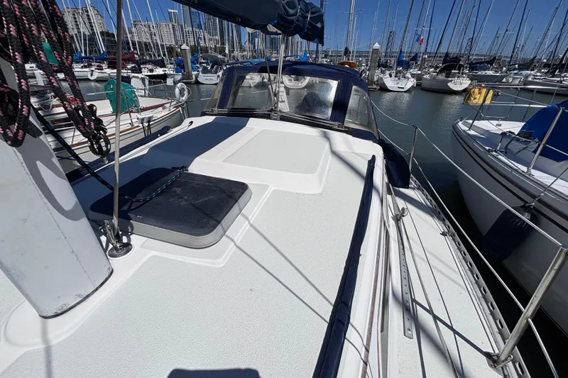 Slide: The Image of 1984 Islander 28 sailboat docked in marina, surrounded by other boats and city skyline. - 24