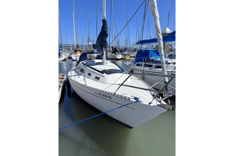 The Image of 1984 Islander 28 sailboat docked in marina, surrounded by other boats. - 1