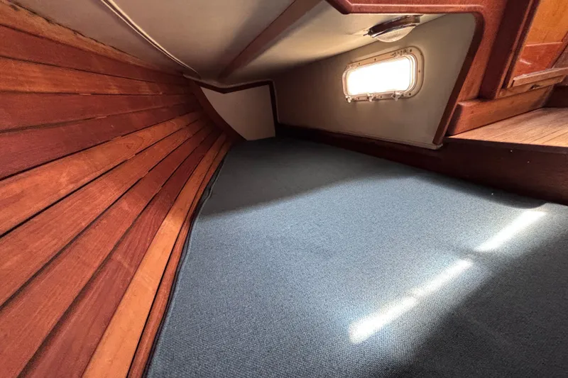 Slide: The Image of Interior cabin of 1984 Islander 28 sailboat with wooden paneling and carpeted floor. - 14