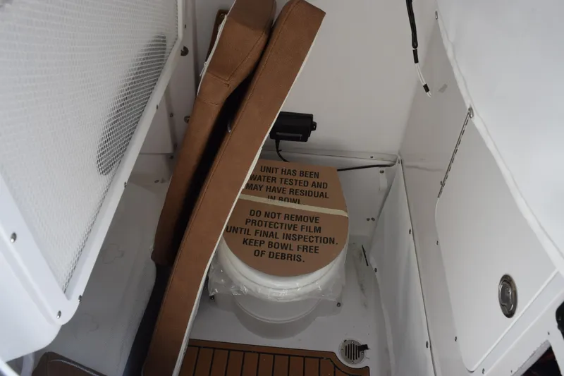Slide: The Image of 2026 Sea Hunt Gamefish 25 boat interior with protective film on toilet. - 16