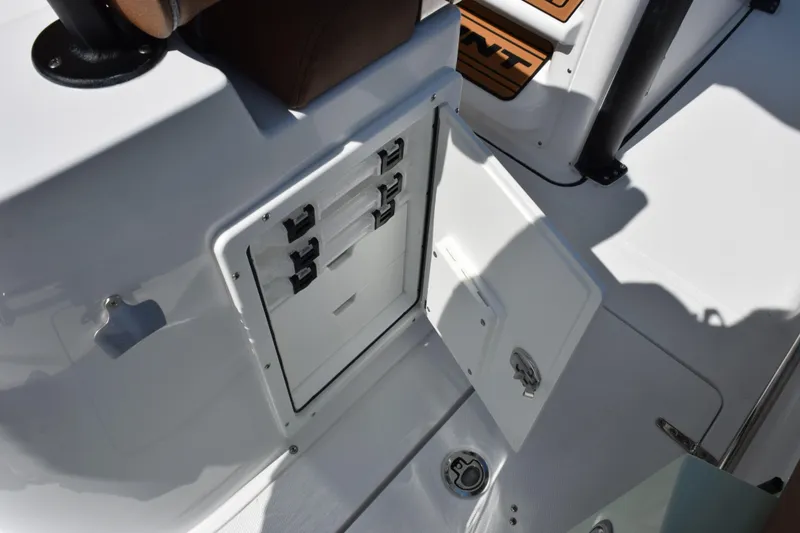 Slide: The Image of 2026 Sea Hunt Gamefish 25 boat storage compartment with open hatch and secure latches. - 19