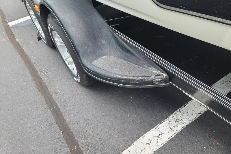 Slide: The Image of 2012 Bass Cat Cougar FTD trailer detail, showing wheel and fender in parking lot. - 11