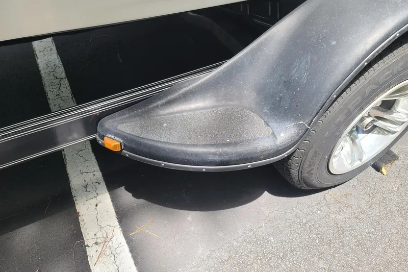 Slide: The Image of 2012 Bass Cat Cougar FTD trailer fender with tire on asphalt. - 10