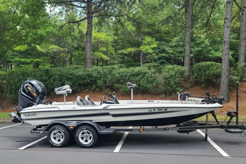 Slide: The Image of 2012 Bass Cat Cougar FTD boat on trailer in wooded parking area. - 8