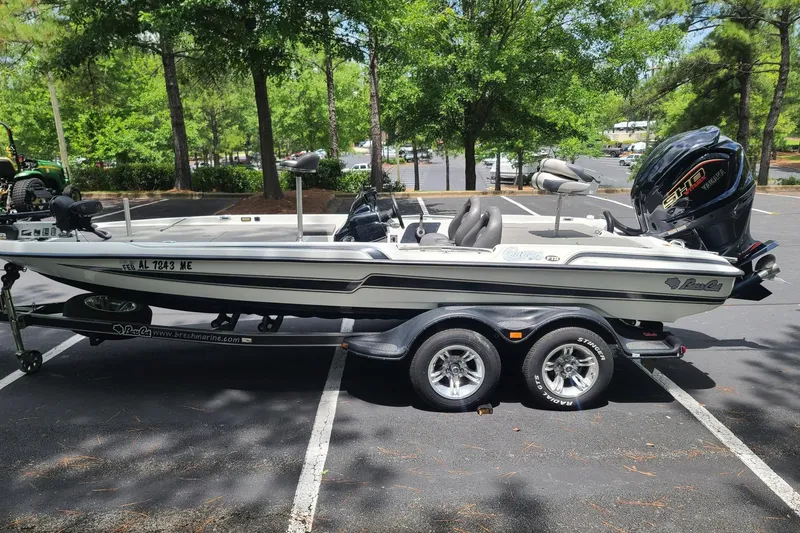 The Image of 2012 Bass Cat Cougar FTD boat on trailer in a sunny parking lot. - 1