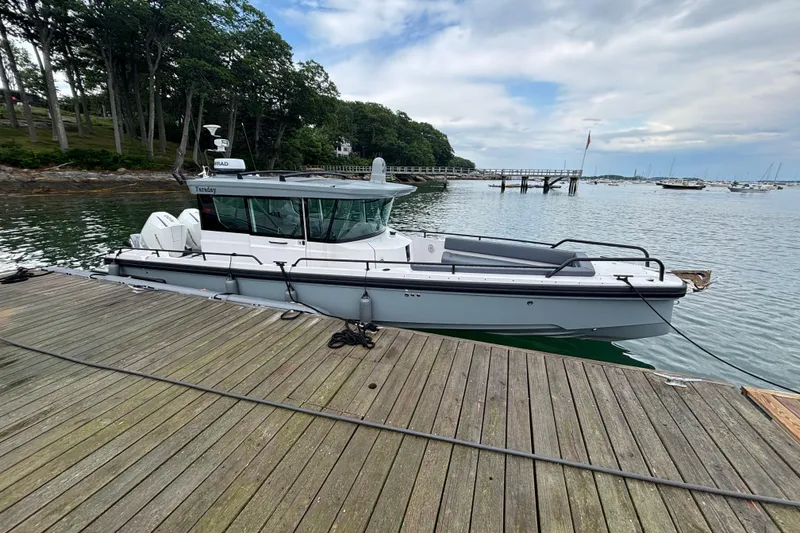 The Image of 2021 Axopar 28 Cabin boat docked by a scenic waterfront. - 0