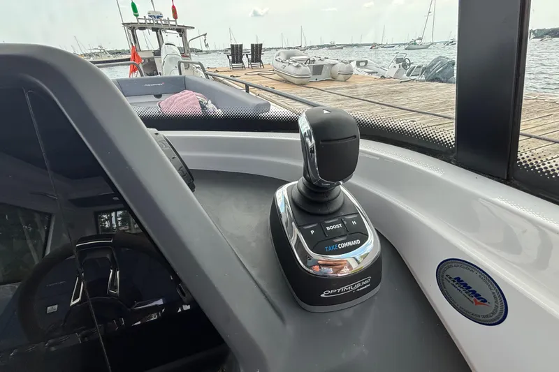 Slide: The Image of Joystick control on 2021 Axopar 28 Cabin boat, docked with water view. - 19