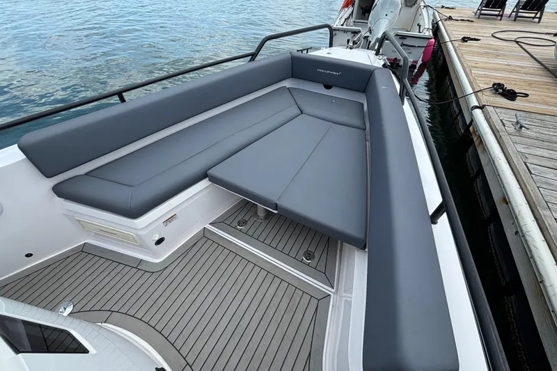 Slide: The Image of 2021 Axopar 28 Cabin boat with sleek gray seating and wooden deck. - 11