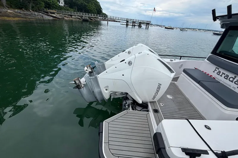 Slide: The Image of 2021 Axopar 28 Cabin with twin Mercury outboards docked on calm waters. - 7