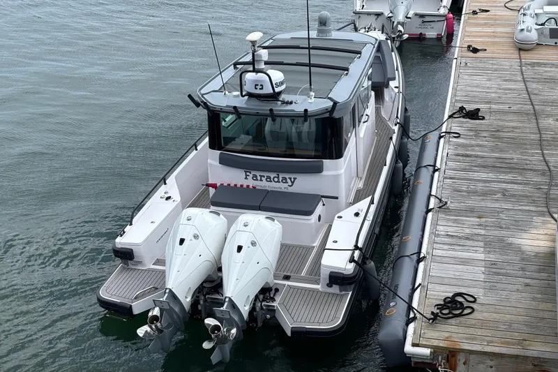 Slide: The Image of 2021 Axopar 28 Cabin boat docked with twin engines, viewed from above. - 5